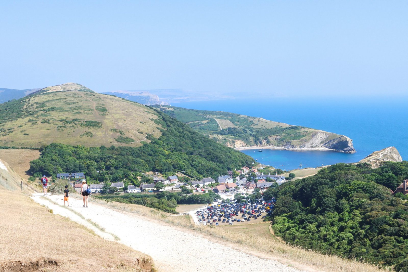 Hiker in blue climbing over a coastal footpath style